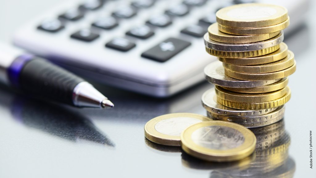 Schmuckbild: Taschenrechner und Münzgeldstapel